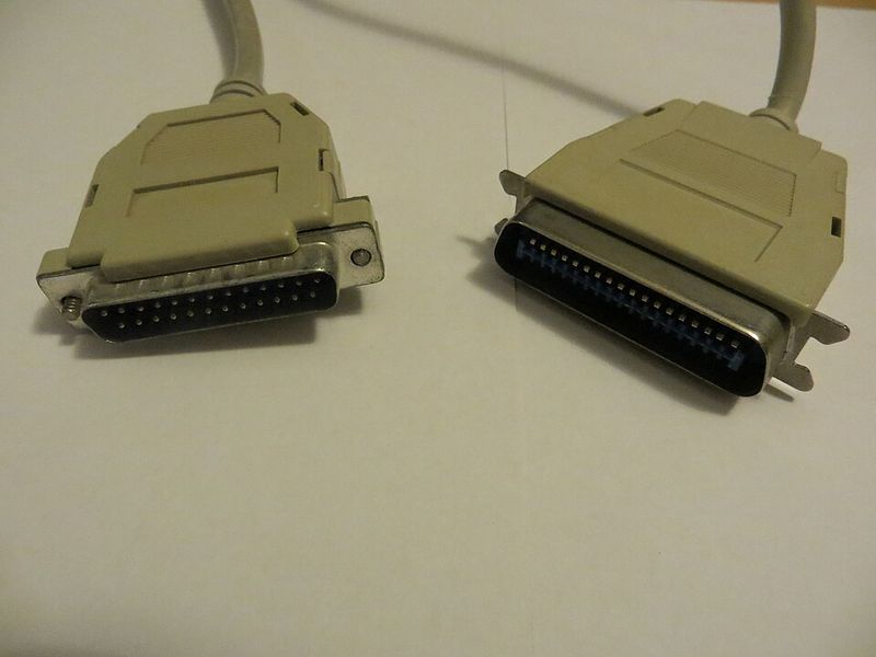 Two ends of an old parallel printer cable: a 25-pin plug and a wide 36-pin Centronics plug