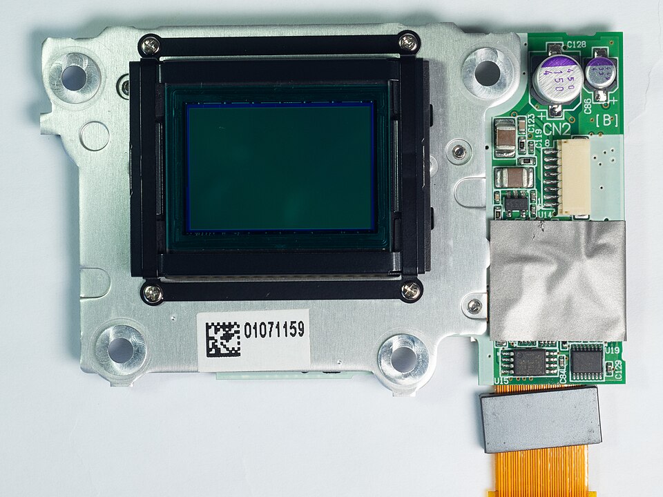 A rectangular CCD image sensor removed from a camera, mounted on a metal plate with a small circuit board