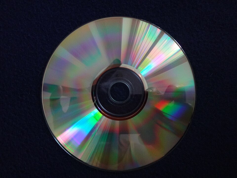 A compact disc showing a rainbow reflection on its data side
