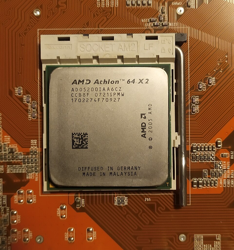 An AMD Athlon 64 X2 processor fitted in its socket on an orange motherboard