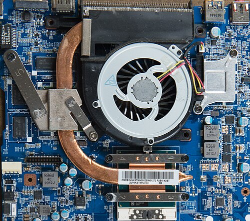 Inside a laptop: a copper heat pipe runs from the processor to a fan and metal fins