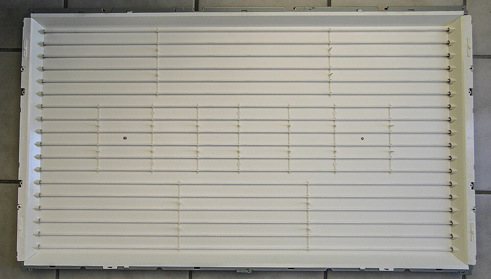 The back panel of an old LCD TV with long thin fluorescent tubes running across it