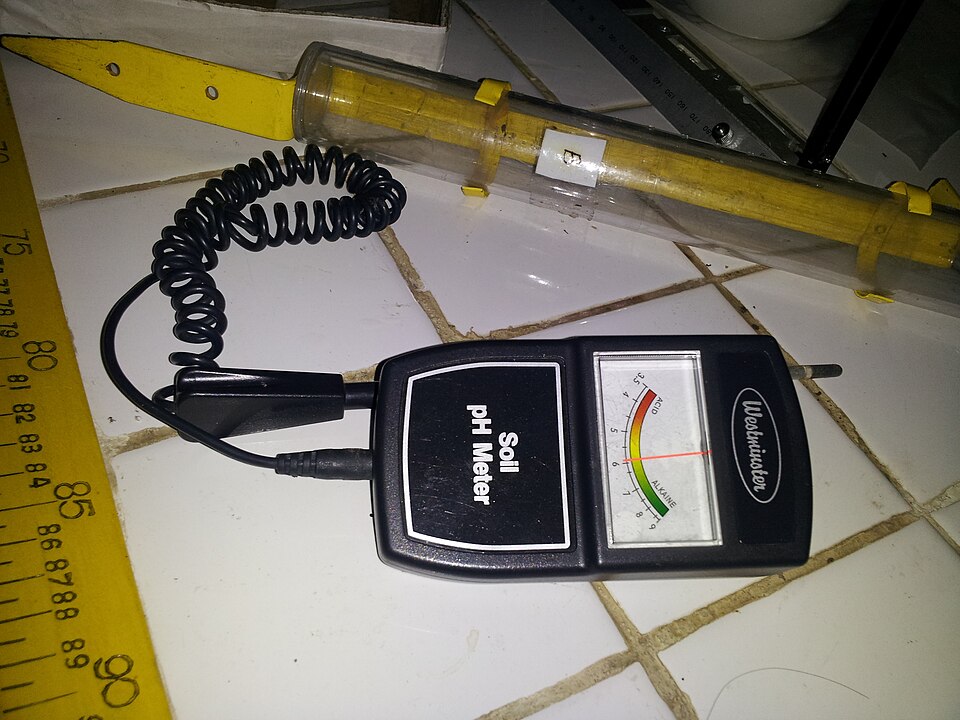 A handheld soil pH meter with a dial and a probe on a cable
