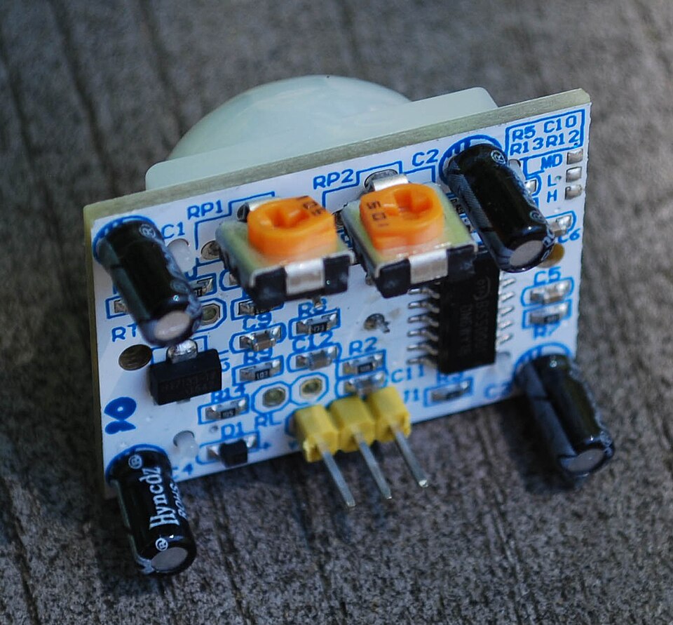 A small passive infrared motion sensor board with a white dome lens