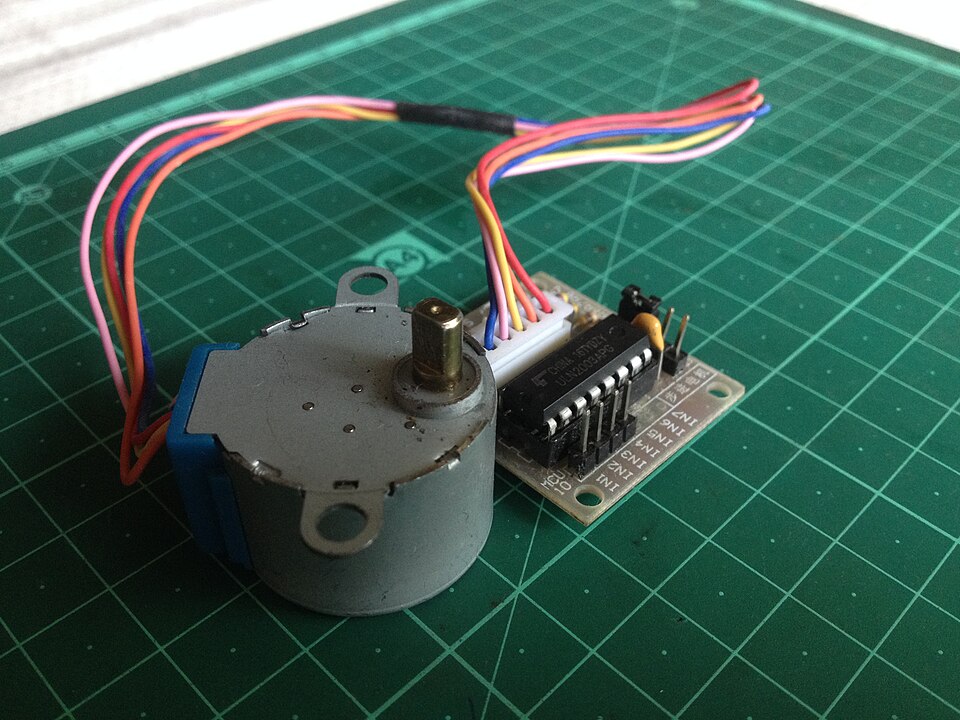A small round stepper motor wired to a driver circuit board