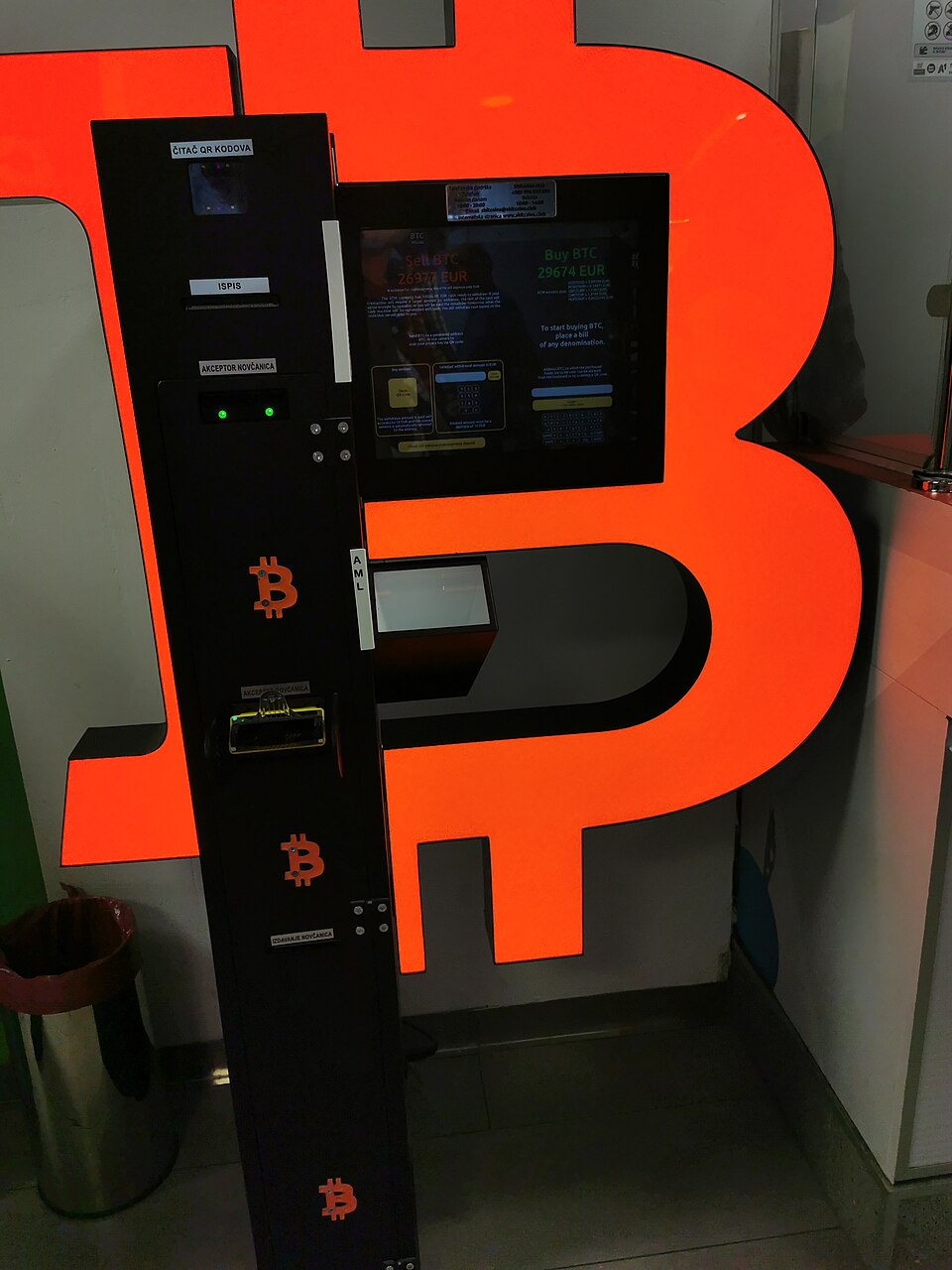 A cryptocurrency cash machine shaped like a large orange letter B in a shopping centre