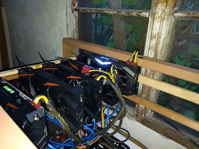 An open-frame computer rig holding five graphics cards used for cryptocurrency mining