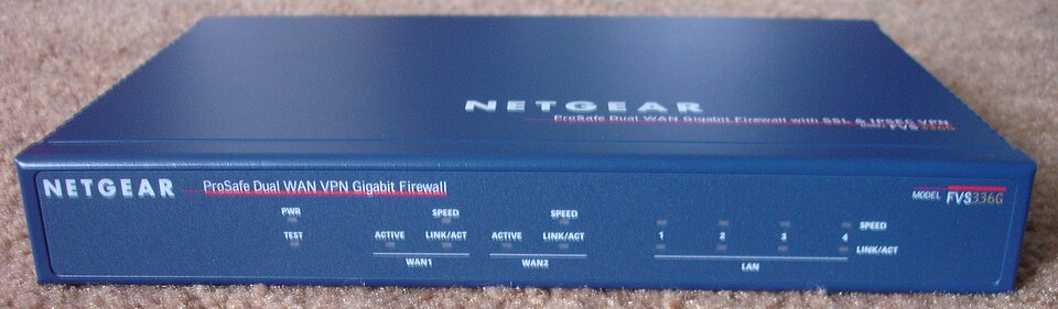 The front panel of a small blue hardware firewall box with status lights for two internet connections and four network ports