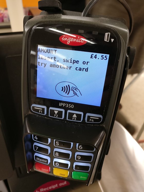 A hand-held card payment terminal showing a contactless payment screen
